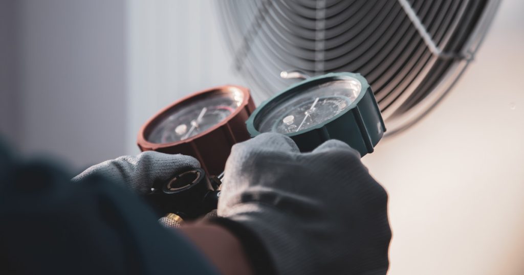 hands holding heating and cooling gauges