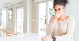 woman holding her nose